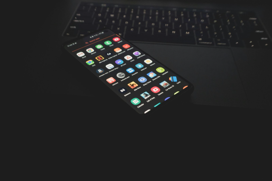 Handphone yang tergeletak di atas laptop